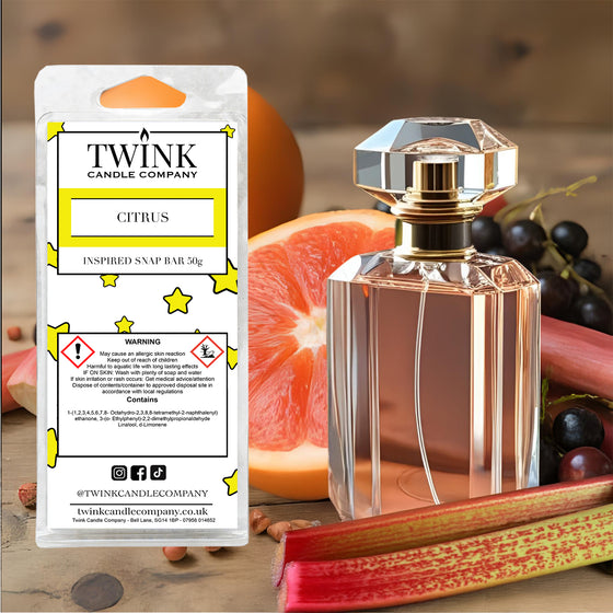 Citrus inspired soy wax melt snap bar by Twink Candle Company, with a perfume bottle, grapefruit and grapes