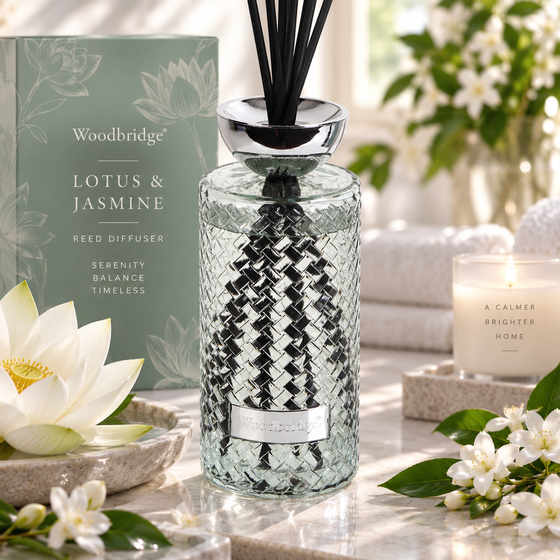 Woodbridge Lotus & Jasmine 1000ml reed diffuser — clear glass bottle with rattan reeds in a soft floral home setting