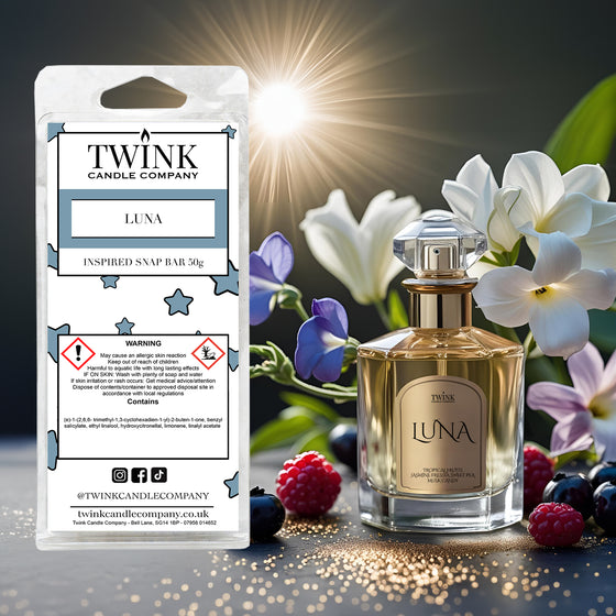 Luna inspired soy wax melt snap bar by Twink Candle Company, with a gold perfume bottle, flowers and berries in sunlight