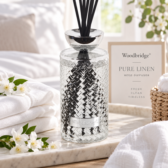 Woodbridge Pure Linen 1000ml reed diffuser — clear glass bottle with rattan reeds in a fresh, clean home setting