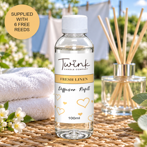 Fresh Linen reed diffuser refill by Twink Candle Company, a 100ml bottle on a rattan mat by a washing line of fresh laundry