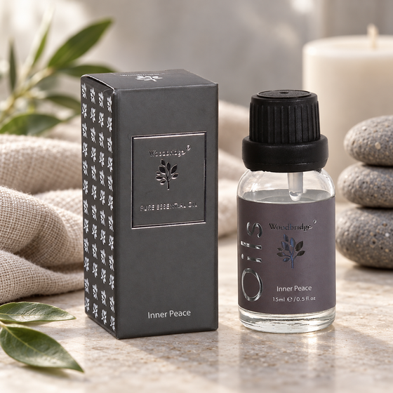 Woodbridge Inner Peace essential oil 15ml bottle and box on pale stone with stacked pebbles and soft linen