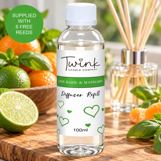 Lime, Basil & Mandarin reed diffuser refill by Twink Candle Company, a 100ml bottle on an olive wood board with fresh limes, mandarins and basil