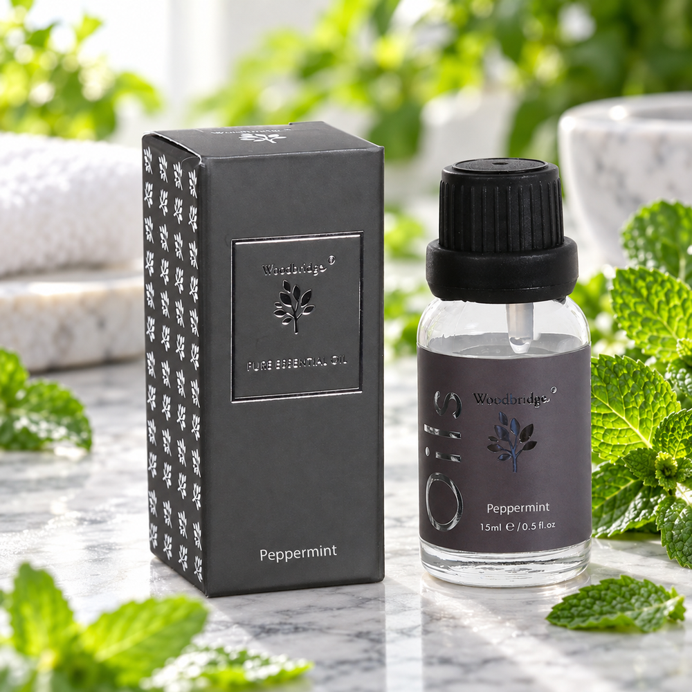 Woodbridge Peppermint essential oil 15ml bottle and box on pale marble with fresh peppermint sprigs