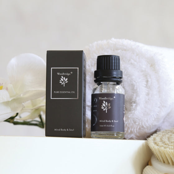 Woodbridge Mind Body & Soul essential oil 15ml bottle and box styled with a towel and flowers