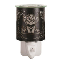 Highland cow black plug-in wax and oil burner by Twink Candle Company, lit, showing the plug