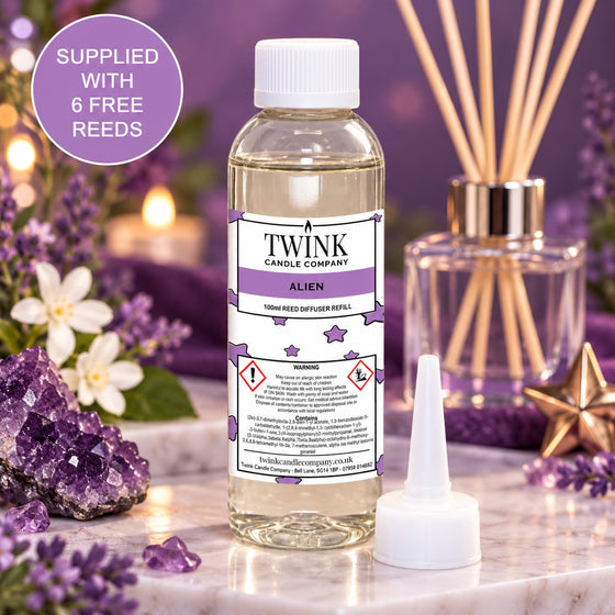 Aliens reed diffuser refill by Twink Candle Company, a 100ml bottle among soft purple orchids and candlelight