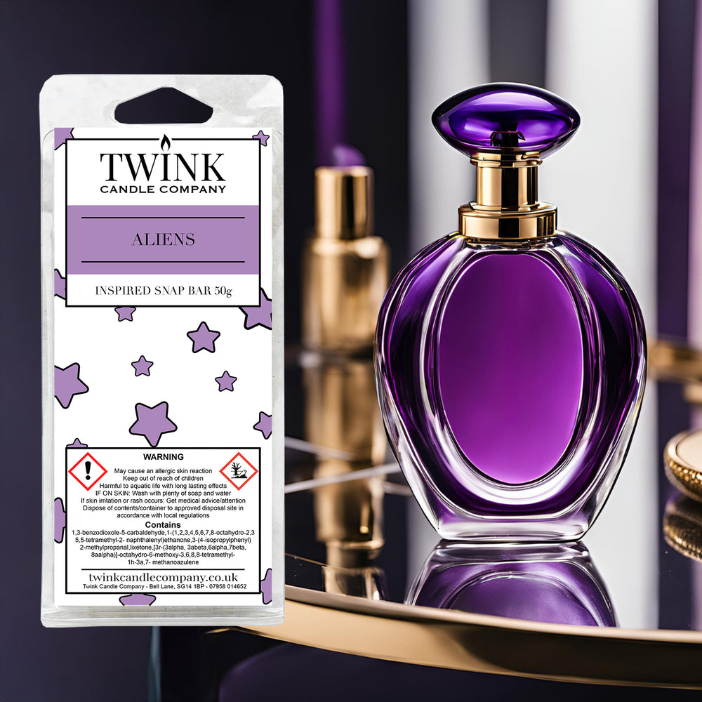 Aliens inspired soy wax melt snap bar by Twink Candle Company, beside a purple glass perfume bottle