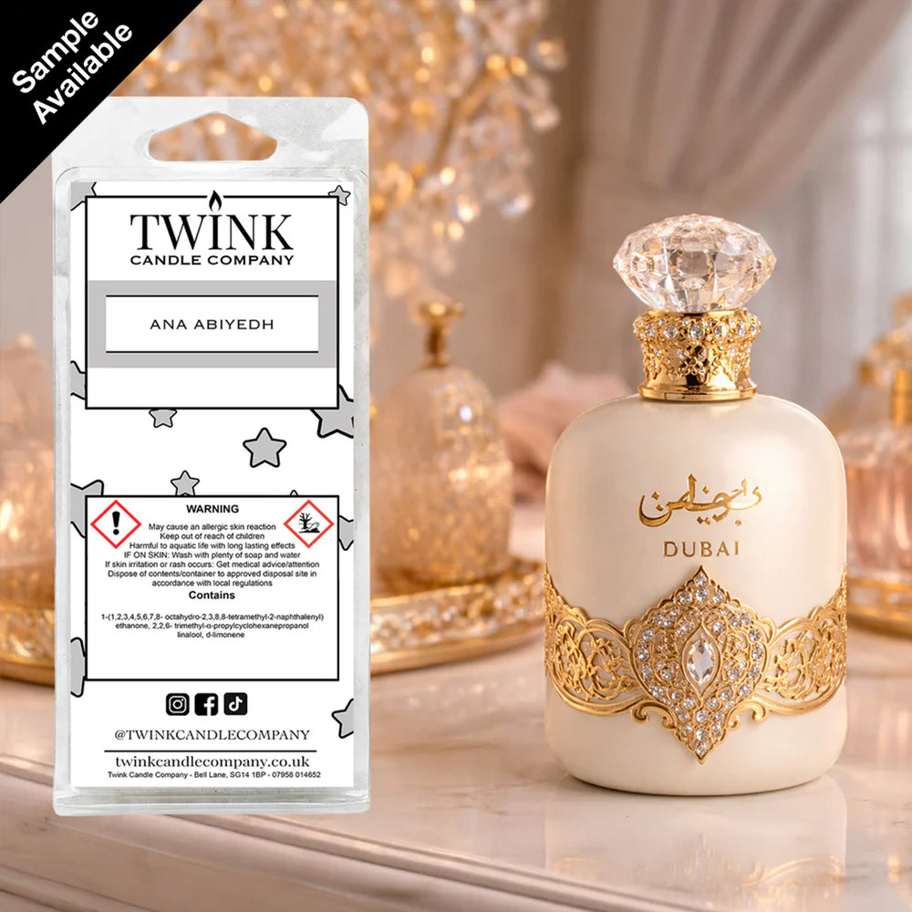 Ana Abiyedh inspired soy wax melt snap bar by Twink Candle Company, beside an ornate gold and white perfume bottle