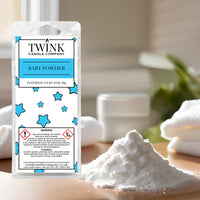 Baby Powder soy wax melt snap bar by Twink Candle Company, beside a soft mound of powder and a folded white towel