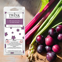 Black Plum & Rhubarb soy wax melt snap bar by Twink Candle Company, with fresh rhubarb stalks and dark plums on a wooden board