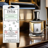Eventos inspired soy wax melt snap bar by Twink Candle Company, beside a dark glass perfume bottle on a polished surface