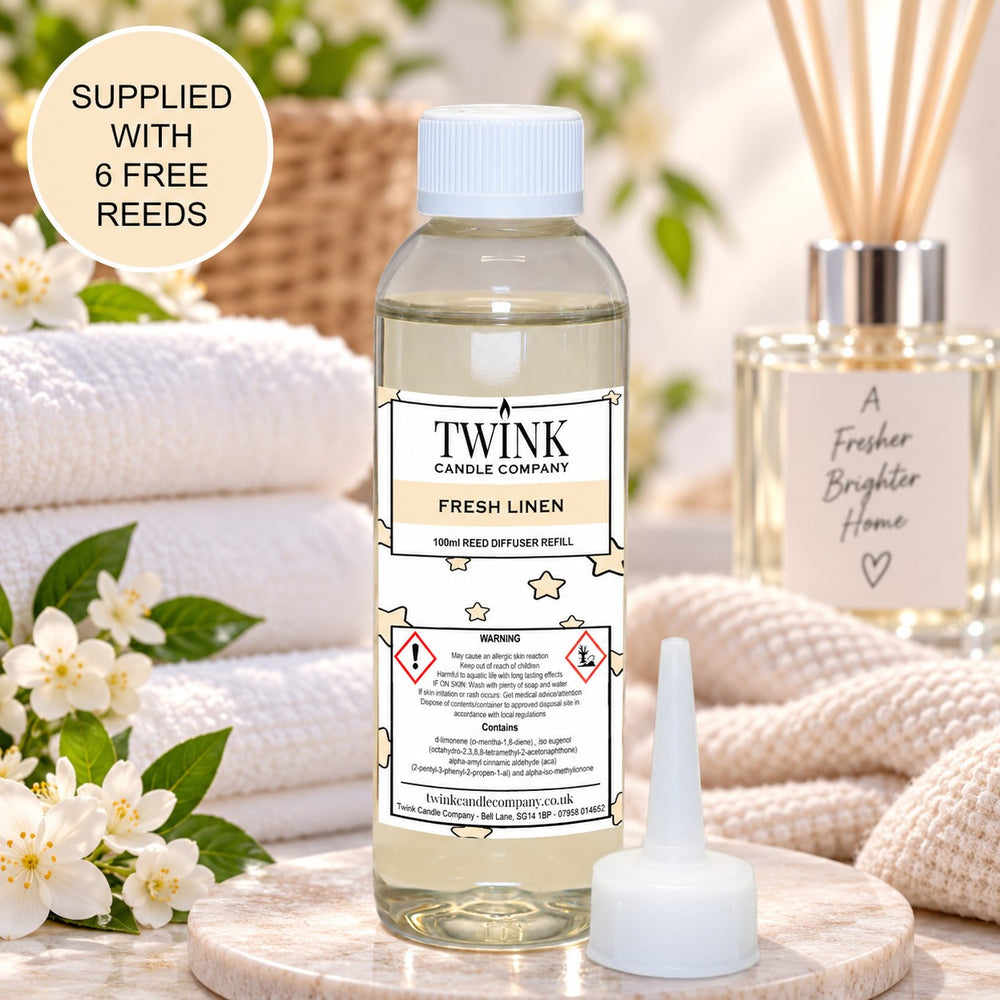 Fresh Linen reed diffuser refill by Twink Candle Company, a 100ml bottle among fresh laundry and towels