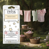 Fresh Linen inspired soy wax melt snap bar by Twink Candle Company, with laundry drying on a washing line beside wicker baskets