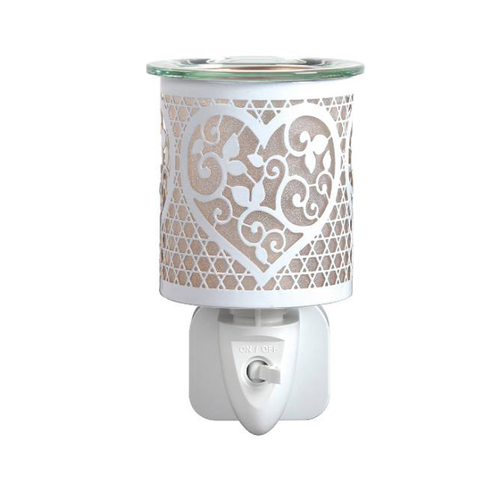 White heart cutout plug-in wax and oil burner by Twink Candle Company, shown lit
