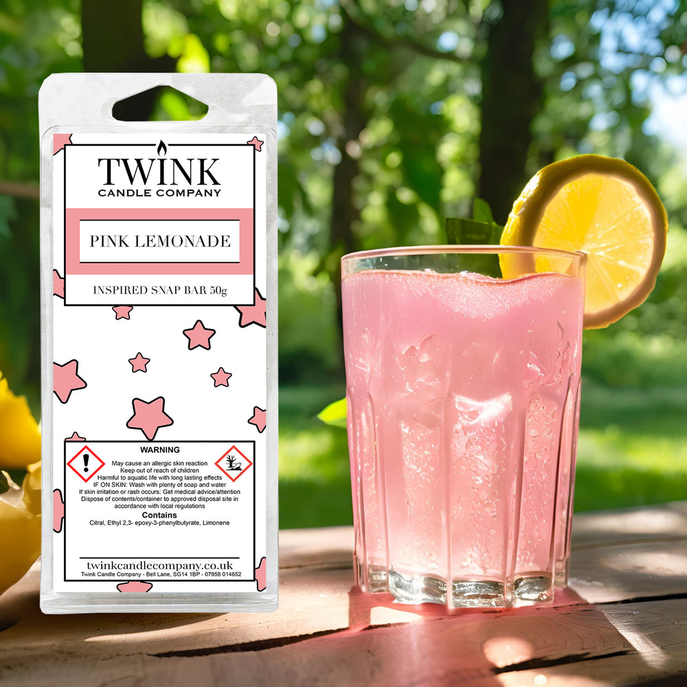 Pink Lemonade soy wax melt snap bar by Twink Candle Company, beside a tall glass of pink lemonade with an orange slice
