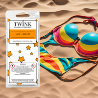Sol-Bikini inspired soy wax melt snap bar by Twink Candle Company, with a brightly striped bikini on golden sand