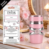 Yara inspired soy wax melt snap bar by Twink Candle Company, beside a pink and silver perfume bottle on a dressing table