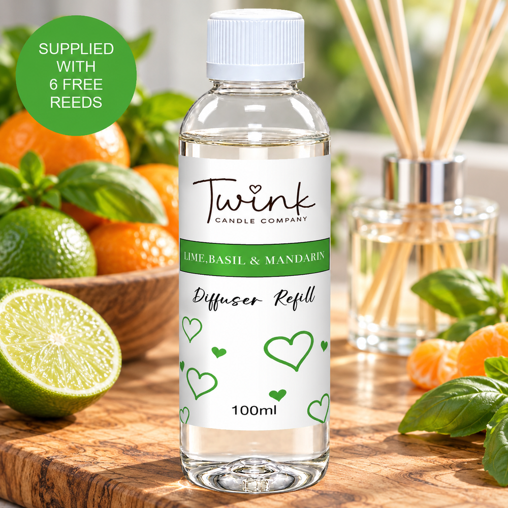 Lime, Basil & Mandarin reed diffuser refill by Twink Candle Company, a 100ml bottle on an olive wood board with fresh limes, mandarins and basil