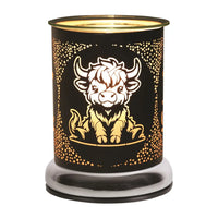 Highland cow black touch melter by Twink Candle Company, shown lit with the gold cow design glowing