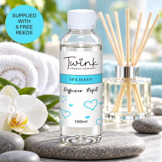 Spa Days reed diffuser refill by Twink Candle Company, a 100ml bottle on a stone slab with rolled white towels and a white orchid