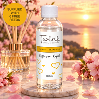 Sunset Blossom reed diffuser refill by Twink Candle Company, a 100ml bottle on a marble coaster with pink cherry blossom and a reed diffuser at sunset