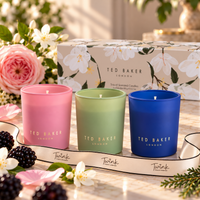 Ted Baker gift set of three 65g scented candles in pink, green and blue glass on pale marble with jasmine, rose, blackberries and cedar, and a Twink Candle Company ribbon