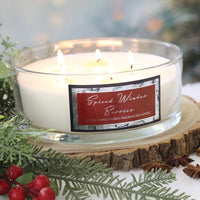 Woodbridge Spiced Winter Berries 5-wick candle bowl lit and styled with pine and berries