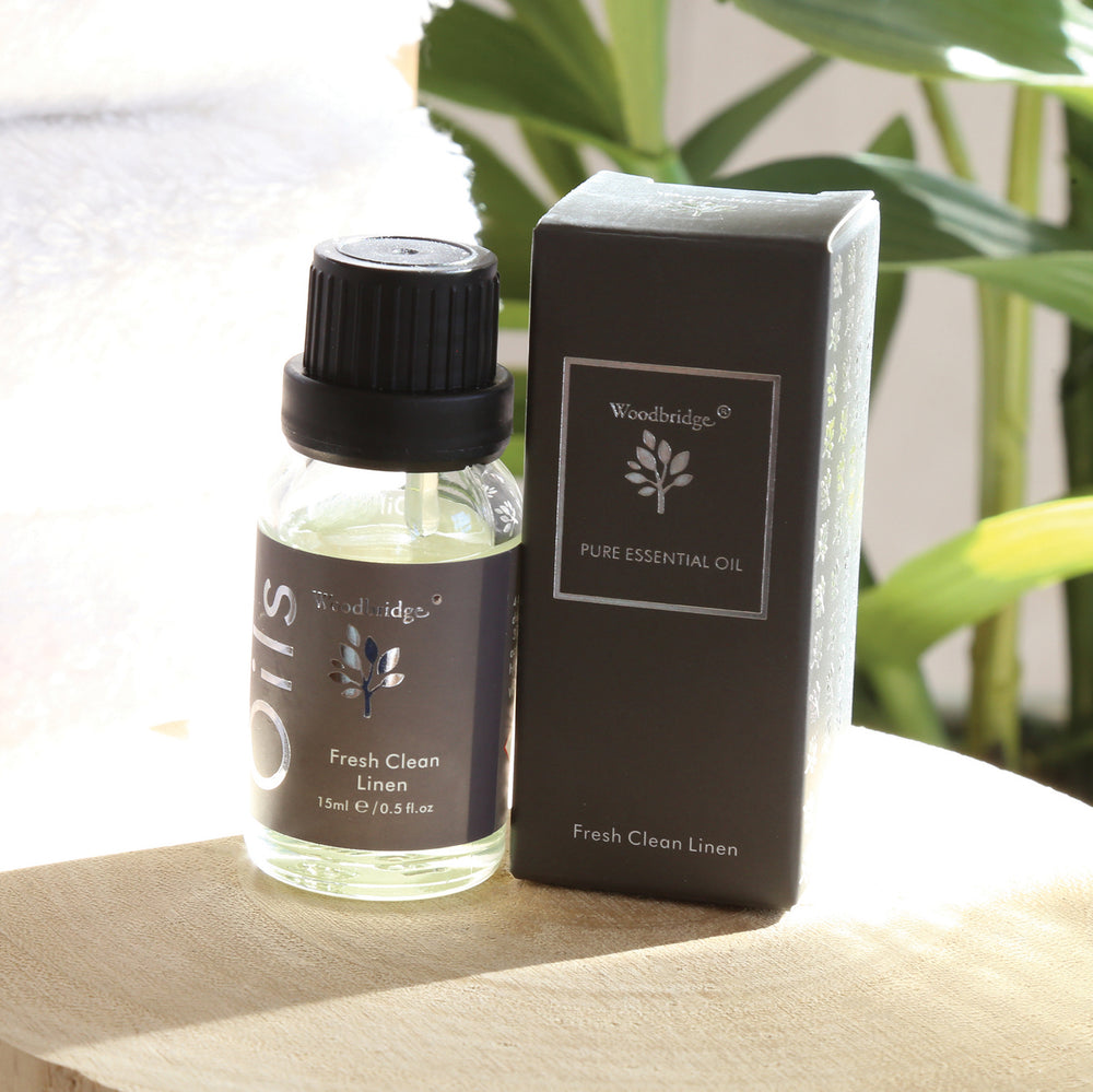 Woodbridge Fresh Clean Linen essential oil 15ml bottle and box styled on wood with a plant behind