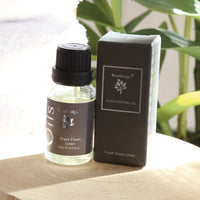 Woodbridge Fresh Clean Linen essential oil 15ml bottle and box styled on wood with a plant behind