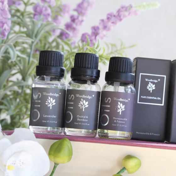 Woodbridge Lavender essential oil 15ml bottle and box styled on wood with a plant behind
